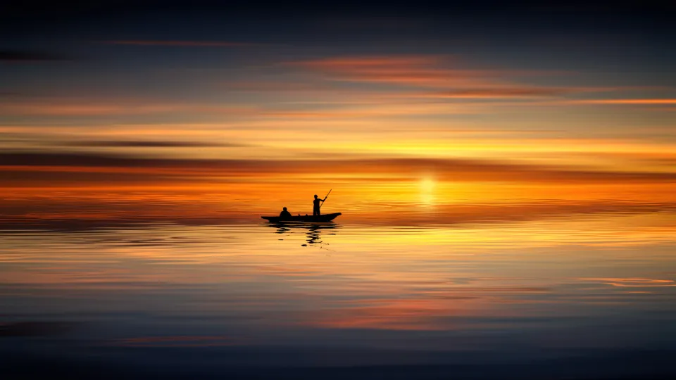 Pemancing di perahu saat matahari terbenam