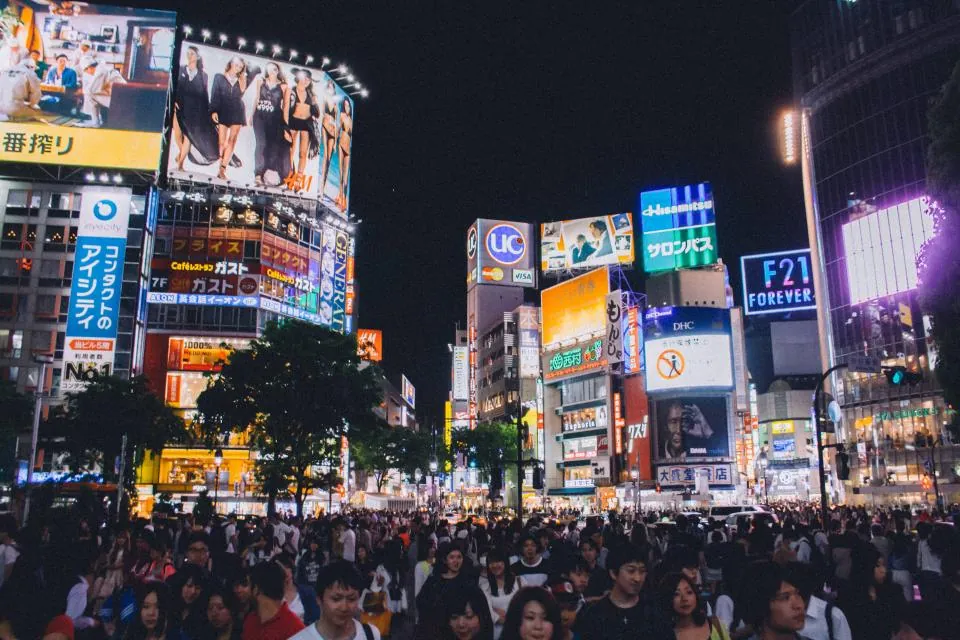 Perempatan kota yang ramai dengan papan iklan menyala